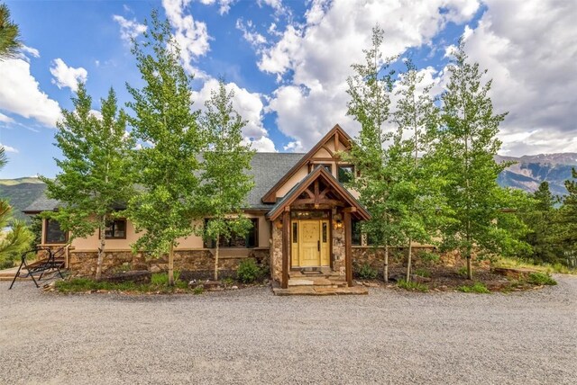 70 County Road 26, Twin Lakes, CO 81251 - rustic home with stone siding, a shingled roof, a mountain view, and stucco siding