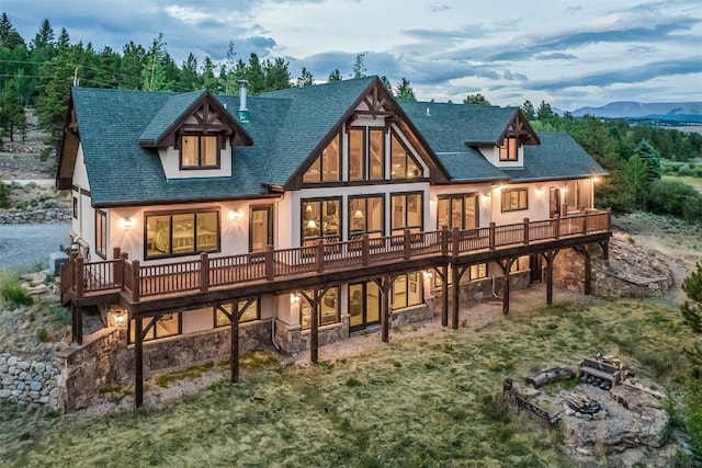 70 County Road 26, Twin Lakes, CO 81251 - back of property with a fire pit, roof with shingles, a deck with mountain view, and stone siding
