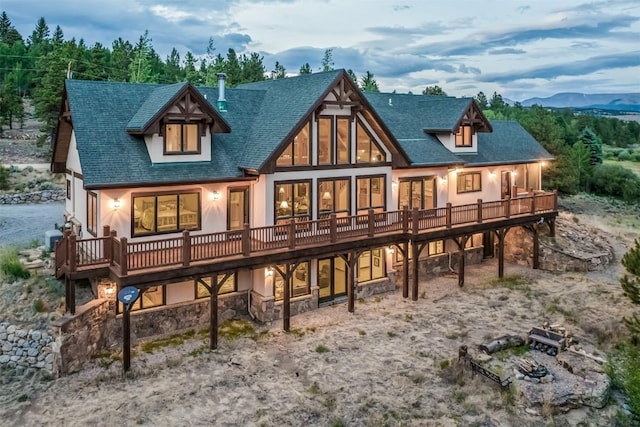 70 County Road 26, Twin Lakes, CO 81251 - rear view of house featuring roof with shingles, a deck with mountain view, and stone siding