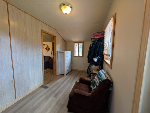 walk in closet featuring visible vents, light wood-type flooring, and lofted ceiling