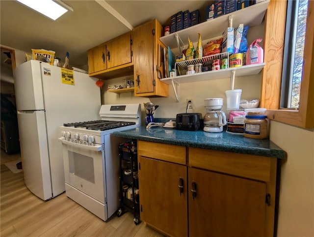 kitchen featuring brown cabinetry, open shelves, dark countertops, white appliances, and light wood finished floors