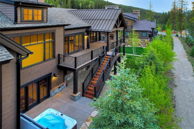 77 E Trade Ct, Keystone, CO 80435 - rear view of house with stairs, a shingled roof, an outdoor hot tub, and a patio area