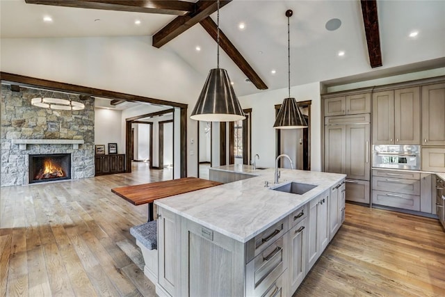 77 E Trade Ct, Keystone, CO 80435 - kitchen with a sink, paneled refrigerator, light wood-style floors, a large island with sink, and beam ceiling
