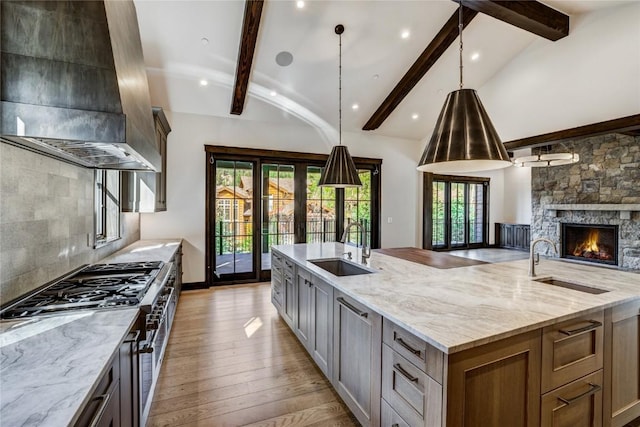 77 E Trade Ct, Keystone, CO 80435 - kitchen with a sink, exhaust hood, open floor plan, a large island, and beamed ceiling