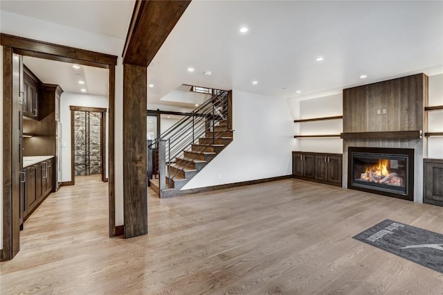 77 E Trade Ct, Keystone, CO 80435 - unfurnished living room featuring baseboards, light wood-style flooring, stairs, a large fireplace, and recessed lighting