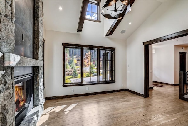 77 E Trade Ct, Keystone, CO 80435 - unfurnished living room with high vaulted ceiling, hardwood / wood-style flooring, a large fireplace, baseboards, and a chandelier