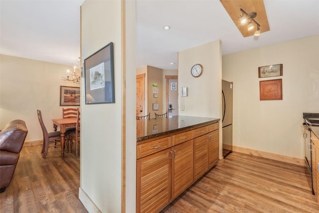 kitchen with light wood-style flooring, baseboards, recessed lighting, a chandelier, and brown cabinets