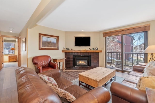 living room with wood finished floors and a brick fireplace