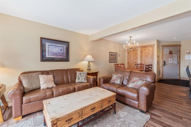 living room with wood finished floors and an inviting chandelier