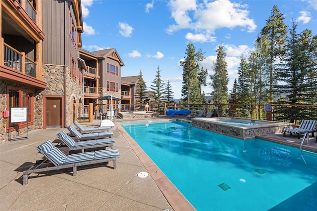 view of swimming pool featuring a patio area and a community hot tub