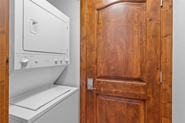 washroom featuring stacked washer and clothes dryer