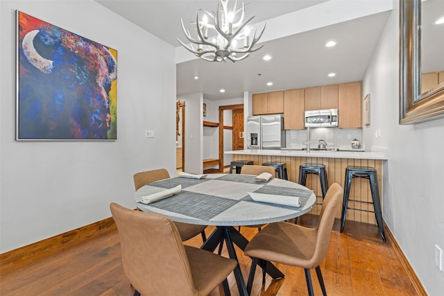 dining room with light hardwood / wood-style flooring and a chandelier