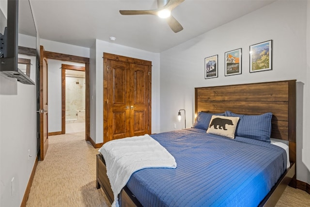 bedroom with ceiling fan, ensuite bathroom, and light carpet