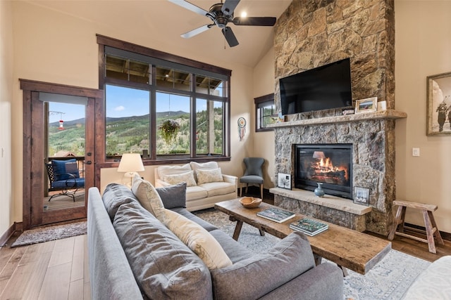 67 Outpost Dr Unit 67, Keystone, CO 80435 - living room featuring wood finished floors, ceiling fan, a stone fireplace, and high vaulted ceiling