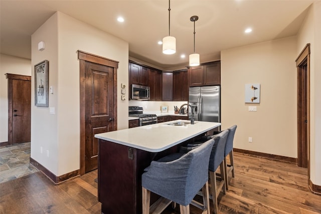 67 Outpost Dr Unit 67, Keystone, CO 80435 - kitchen with appliances with stainless steel finishes, light countertops, dark brown cabinets, hanging light fixtures, and a breakfast bar area