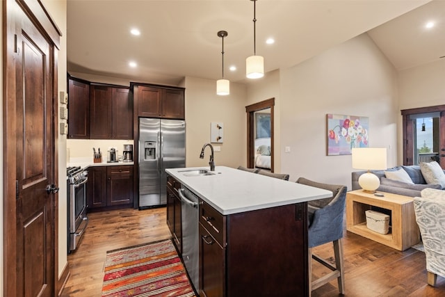 67 Outpost Dr Unit 67, Keystone, CO 80435 - kitchen featuring stainless steel appliances, a kitchen bar, open floor plan, wood finished floors, and light countertops