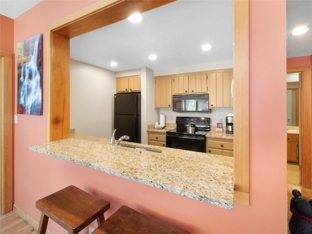 22280 US Highway 6 Unit 1717, Keystone, CO 80435 - kitchen with black appliances, a sink, a peninsula, recessed lighting, and light stone counters