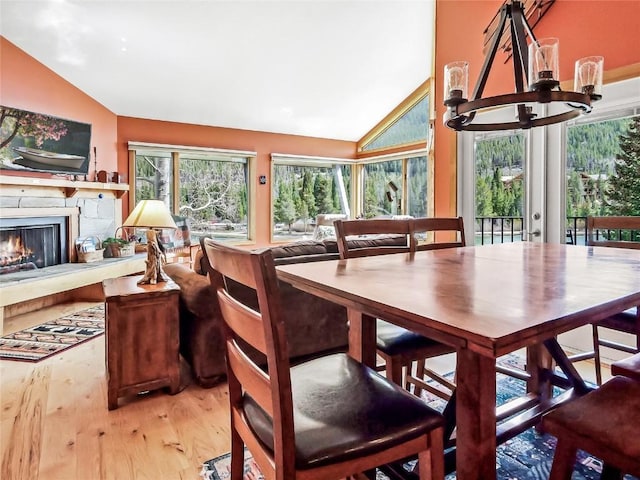 22280 US Highway 6 Unit 1717, Keystone, CO 80435 - dining area with wood finished floors, a chandelier, high vaulted ceiling, and a lit fireplace