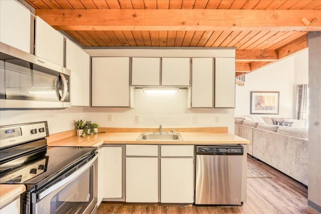 8300 Ryan Gulch Rd Unit F306, Silverthorne, CO 80498 - kitchen with stainless steel appliances, a sink, wooden ceiling, beamed ceiling, and light wood-style flooring