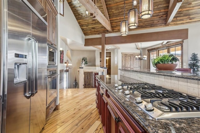 28 Tieze Ln, Keystone, CO 80435 - kitchen featuring built in appliances, dark stone countertops, light wood-type flooring, hanging light fixtures, and wood ceiling
