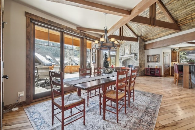 28 Tieze Ln, Keystone, CO 80435 - dining space featuring a chandelier, light wood-style floors, beam ceiling, a fireplace, and high vaulted ceiling