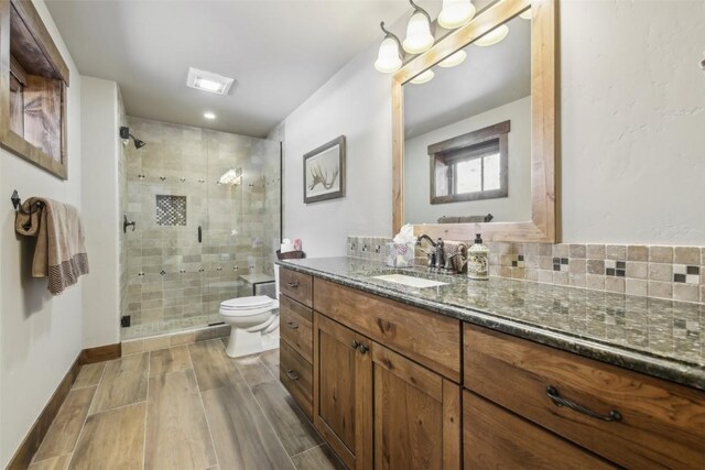 28 Tieze Ln, Keystone, CO 80435 - bathroom featuring vanity, a shower stall, wood finished floors, and backsplash