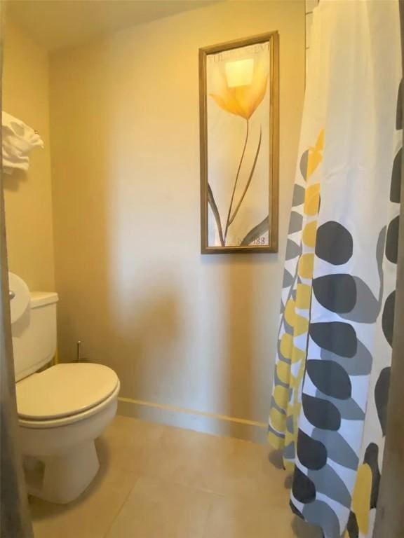 full bath with tile patterned flooring, toilet, baseboards, and a shower with shower curtain