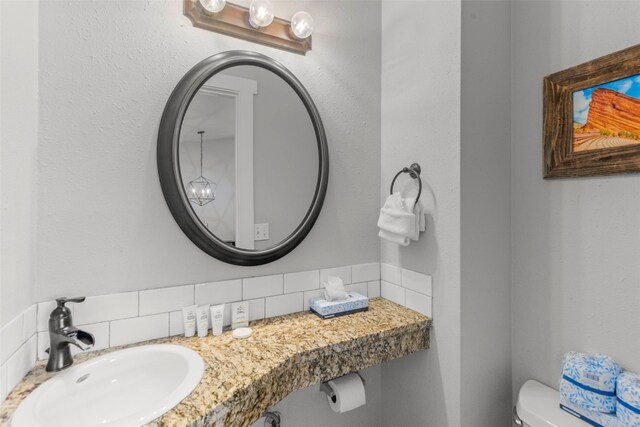 821 Pitkin St Unit 8, Frisco, CO 80443 - half bathroom featuring a sink, toilet, and tasteful backsplash