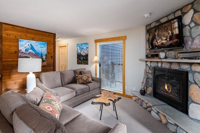 carpeted living room featuring baseboards and a fireplace
