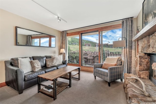 1995 Storm Meadows Dr Unit 307, Steamboat Springs, CO 80487 - living area with light colored carpet, track lighting, and a stone fireplace