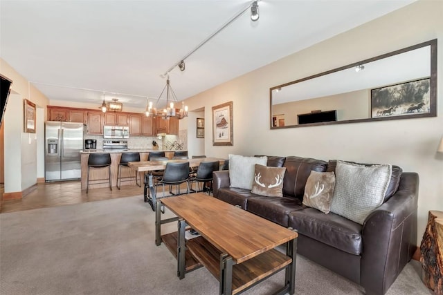 1995 Storm Meadows Dr Unit 307, Steamboat Springs, CO 80487 - living area featuring a chandelier, rail lighting, and light colored carpet