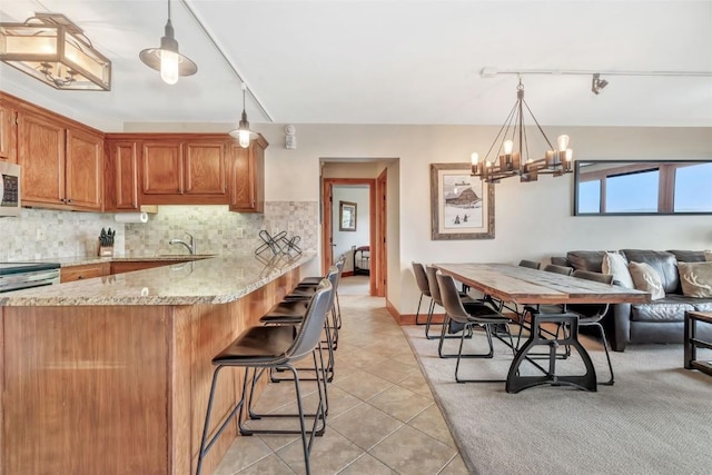 1995 Storm Meadows Dr Unit 307, Steamboat Springs, CO 80487 - kitchen with appliances with stainless steel finishes, backsplash, a chandelier, and light tile patterned floors