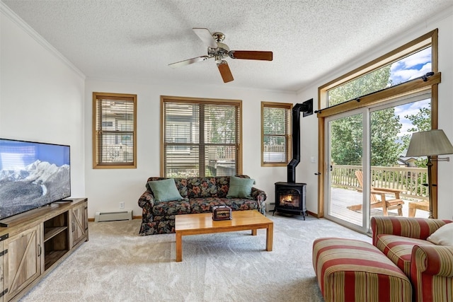 307 Saddle Ridge Dr Unit 307, Wildernest, CO 80498 - living area featuring a baseboard heating unit, a wood stove, light colored carpet, a ceiling fan, and crown molding