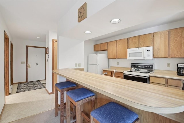 210 E Ln Bonte St Unit 121, Dillon, CO 80435 - kitchen with white appliances, light countertops, a breakfast bar, recessed lighting, and light carpet