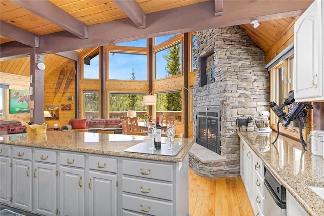 36 Silk Sisters Pl, Fairplay, CO 80440 - kitchen featuring wood ceiling, light wood-style floors, a stone fireplace, white cabinets, and light stone counters