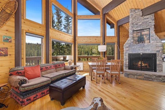 36 Silk Sisters Pl, Fairplay, CO 80440 - living room with high vaulted ceiling, wooden walls, healthy amount of natural light, an outdoor stone fireplace, and wood-type flooring