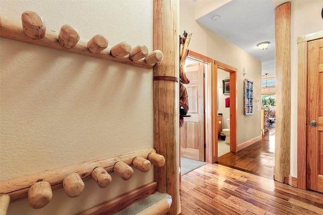 hall featuring baseboards and wood finished floors
