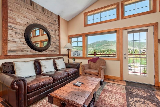 living room with baseboards, plenty of natural light, high vaulted ceiling, and wood finished floors
