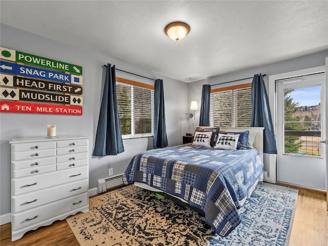 414 Tenderfoot St Unit 1, Dillon, CO 80435 - bedroom with wood finished floors, baseboard heating, and baseboards