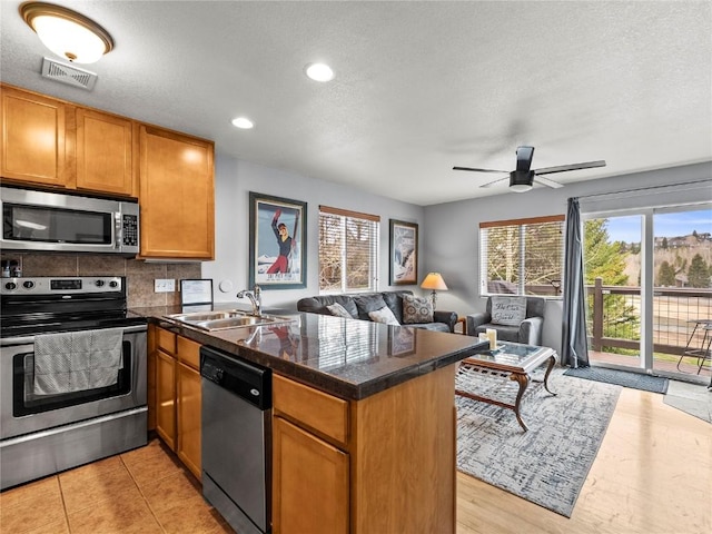 414 Tenderfoot St Unit 1, Dillon, CO 80435 - kitchen with appliances with stainless steel finishes, a peninsula, a sink, open floor plan, and healthy amount of natural light