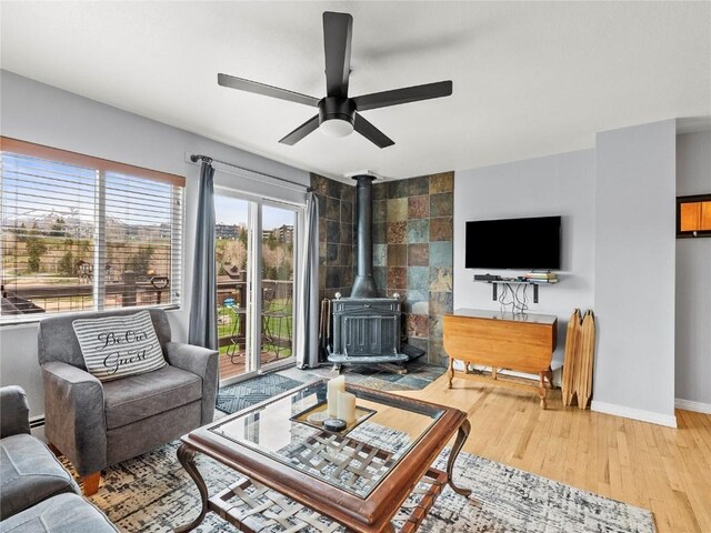 414 Tenderfoot St Unit 1, Dillon, CO 80435 - living room featuring wood finished floors, ceiling fan, a wood stove, and baseboards