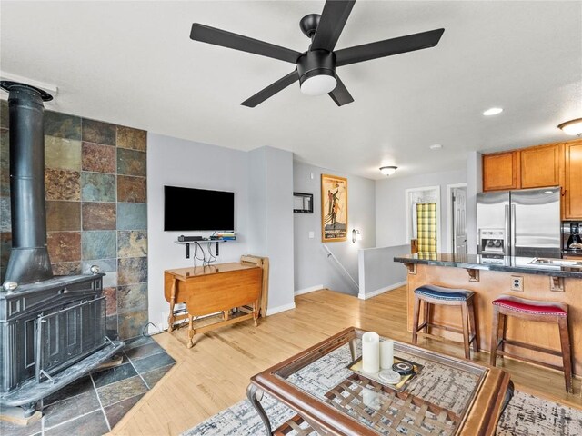 414 Tenderfoot St Unit 1, Dillon, CO 80435 - living area featuring ceiling fan, baseboards, light wood-style flooring, a wood stove, and recessed lighting