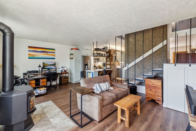 340 Straight Creek Dr Unit 206, Dillon, CO 80435 - living area featuring a textured ceiling, light wood finished floors, and a wood stove