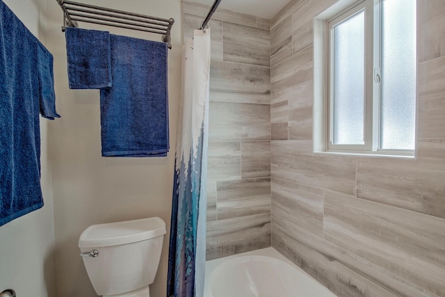 bathroom with toilet, plenty of natural light, and shower / bath combo with shower curtain