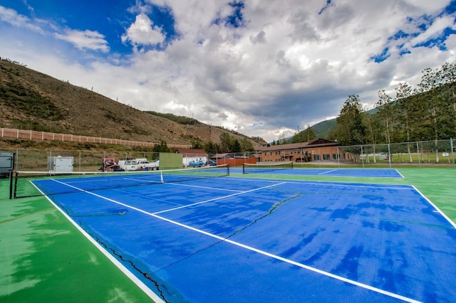 view of sport court with a mountain view and basketball hoop