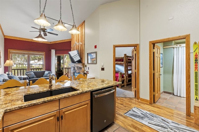 22714 US Highway 6 Unit 5977, Keystone, CO 80435 - kitchen featuring stainless steel dishwasher, a sink, open floor plan, a ceiling fan, and light stone counters