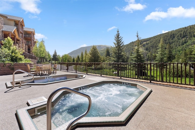 22714 US Highway 6 Unit 5977, Keystone, CO 80435 - view of pool with an outdoor hot tub, a mountain view, a patio, and fence