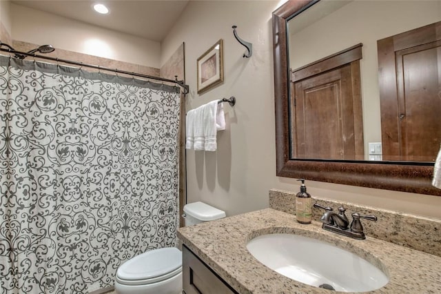 bathroom featuring walk in shower, vanity, and toilet