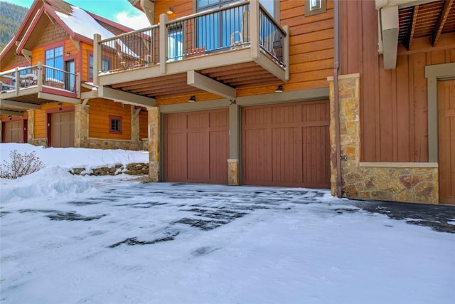 snow covered property featuring a garage