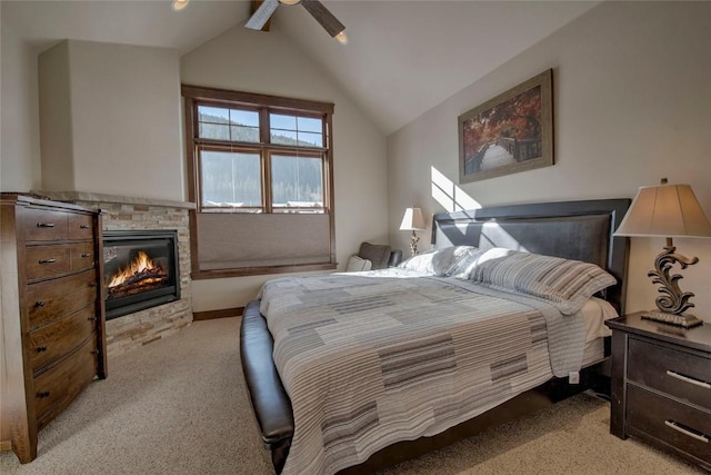 bedroom with light colored carpet, a stone fireplace, ceiling fan, and lofted ceiling